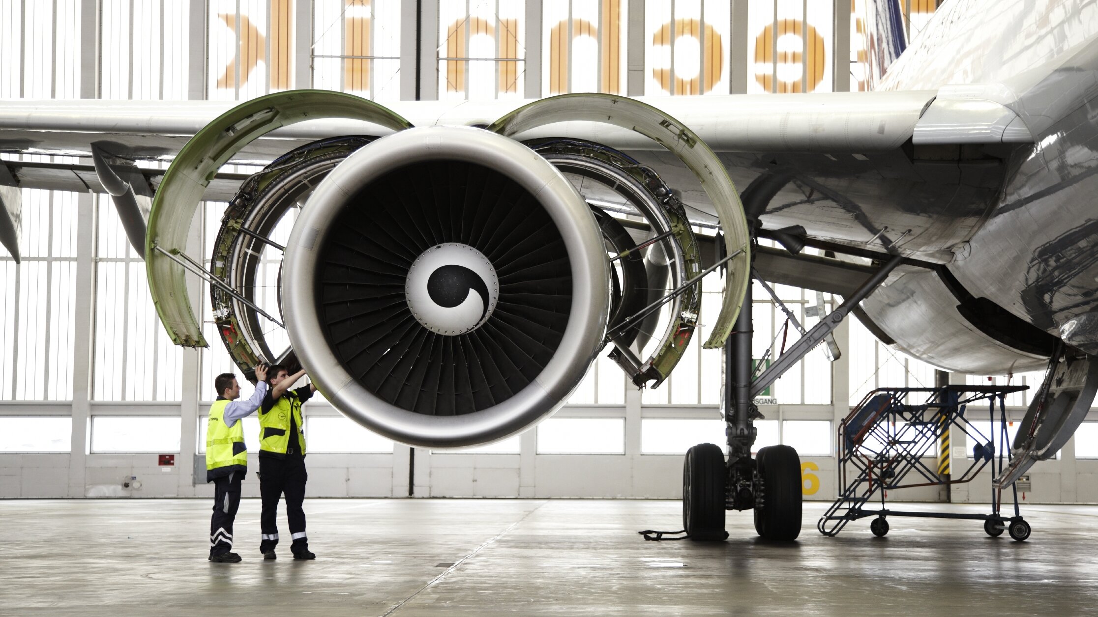 Zwei Techniker bei der Wartung eines Triebwerks im Hangar