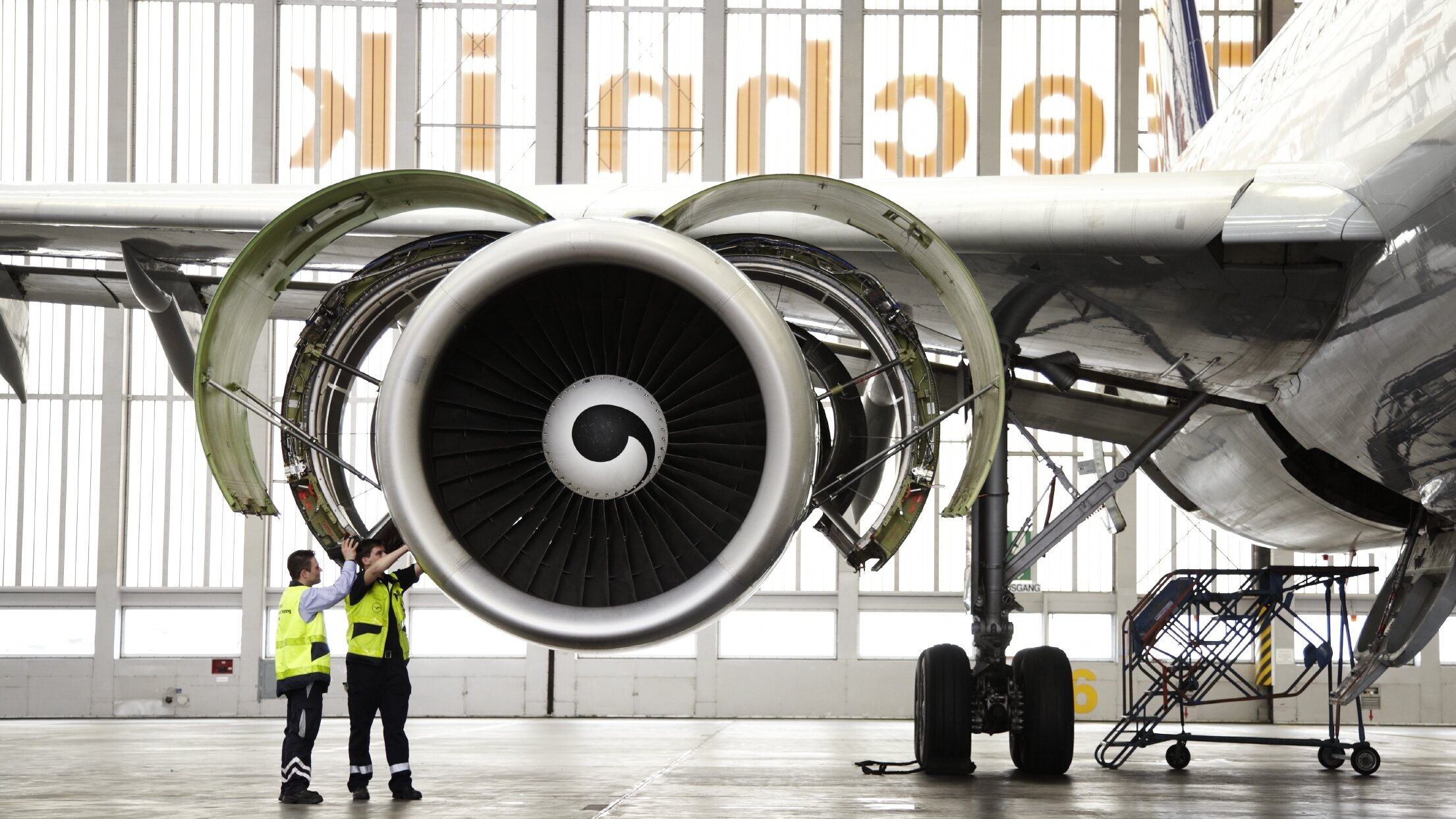 Zwei Techniker bei der Wartung eines Triebwerks im Hangar