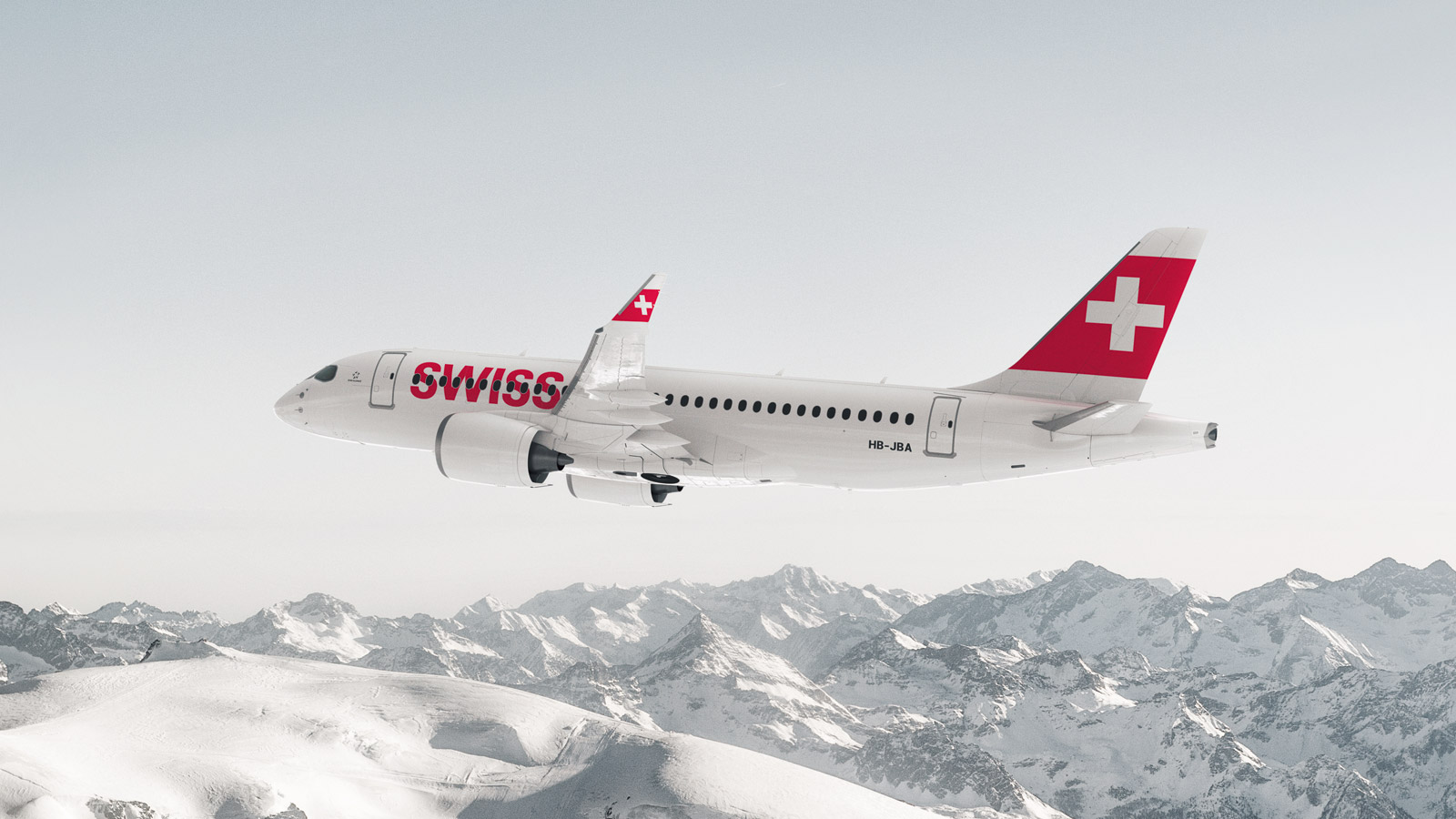 Eine Bombardier CS100 der SWISS über schneebedeckten Bergen