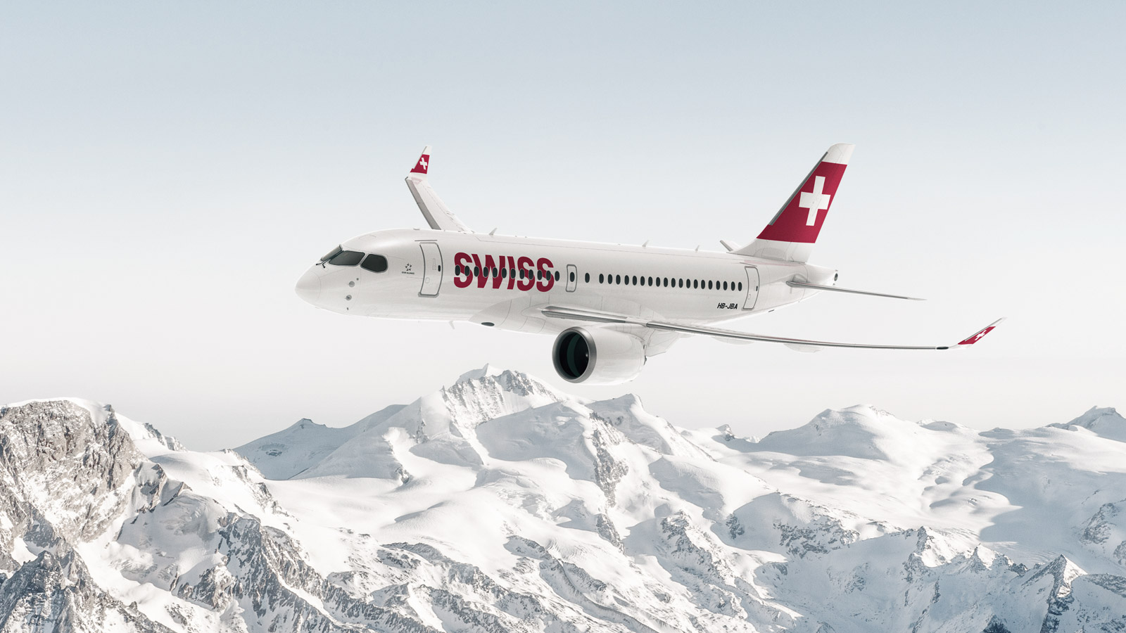 Eine Bombardier CS100 der SWISS über schneebedeckten Bergen